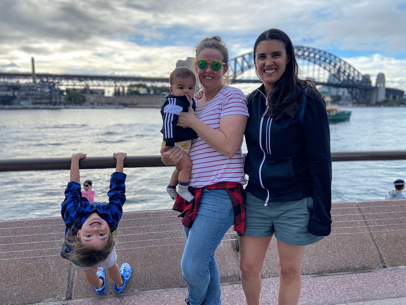 Our family of 4 smiling in front of Sydney Harbour Bridge