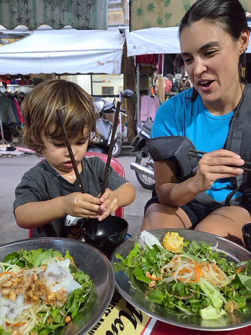 Toddler using chop sticks in Hoi An
