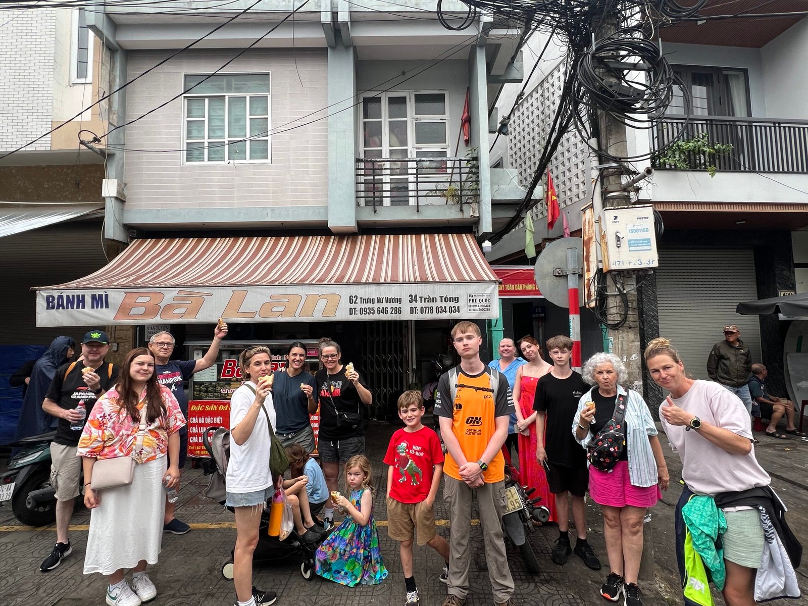 Family in front of a bahn mi stall in Da Nang