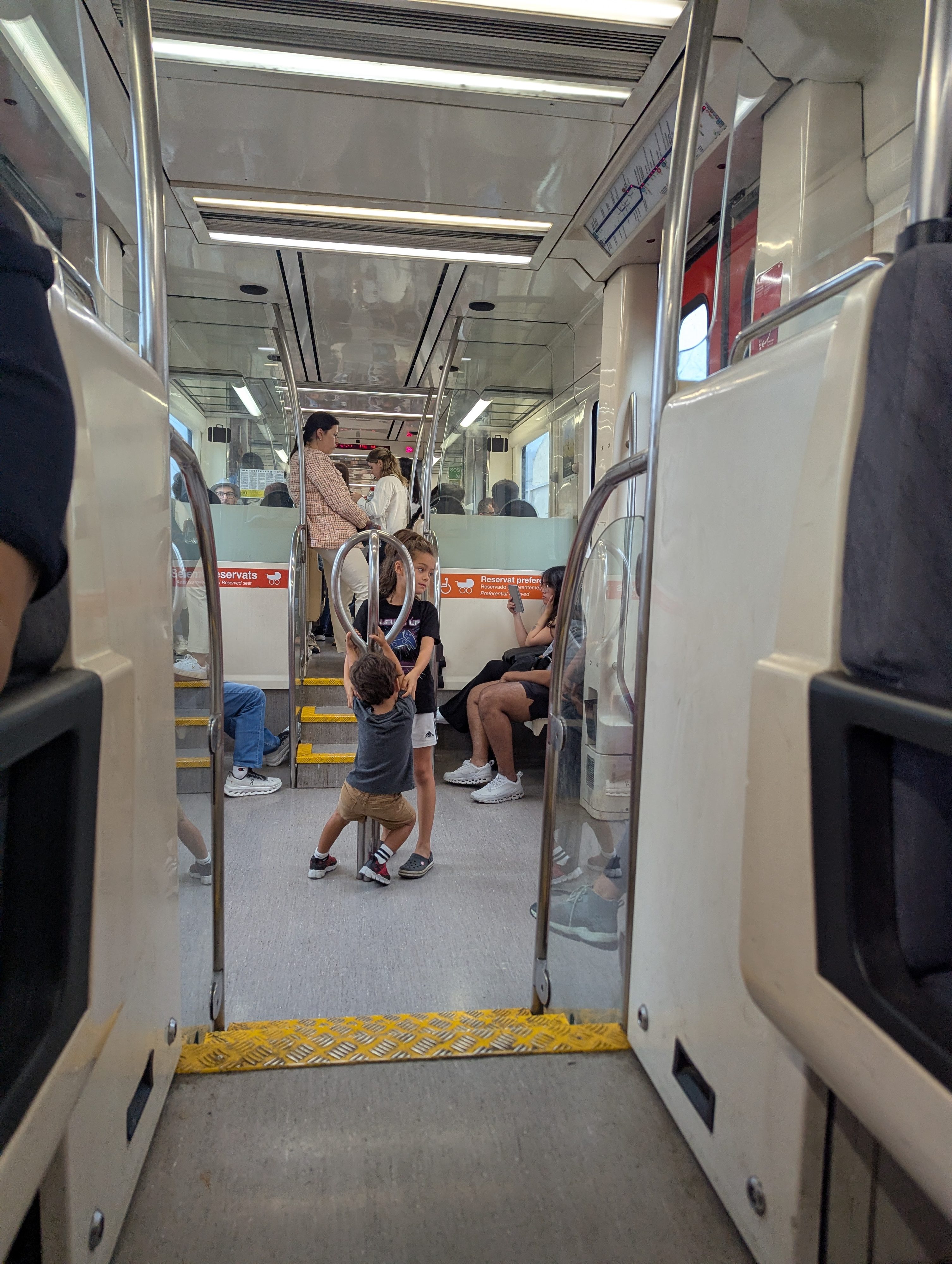 Arlo standing in the aisle of a crowded train carriage on the way to Montserrat, with passengers sitting and standing around him