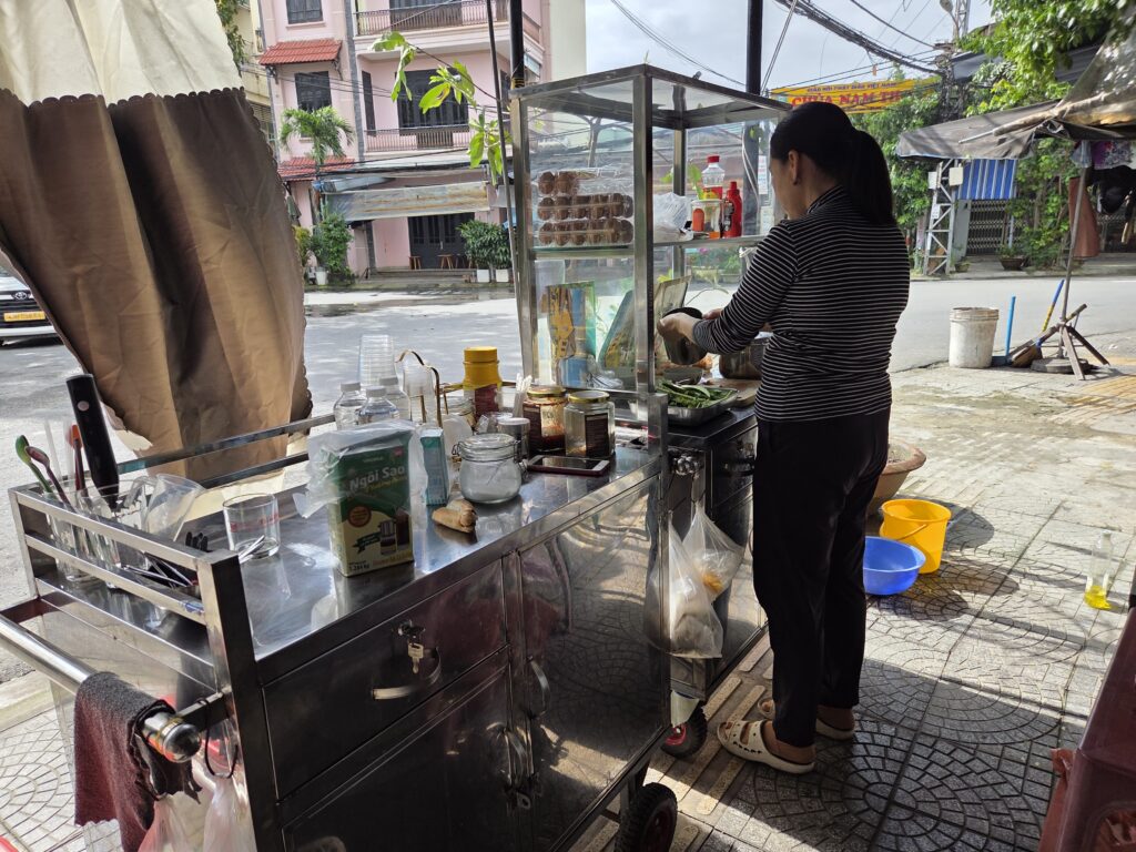 Woman cooking Best bahn mi stall in Hoi An